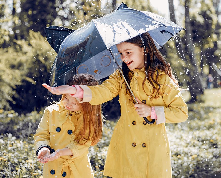 Kinder mit Regenmänteln.