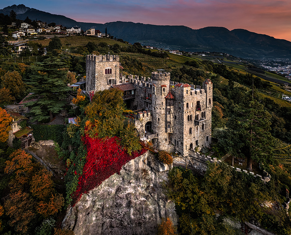 Vista panoramica aerea del famoso Castel Brunnenburg (Castel Tirolo) con la città di Merano