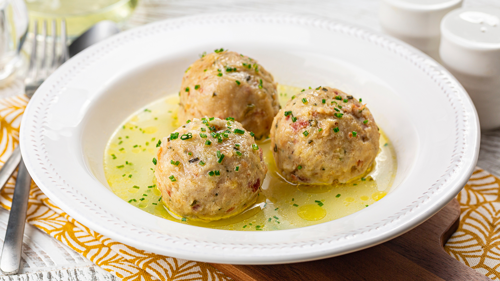Canederli o Knödel in brodo con cipolla verde, pasta o canederli tipici della cucina alpina, altoatesina.
