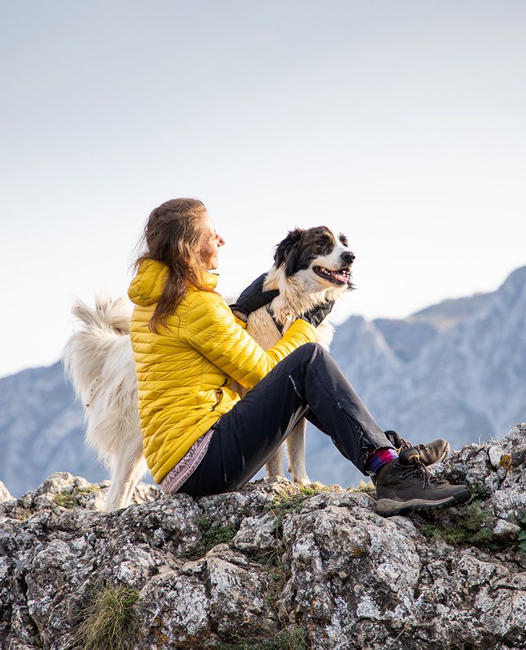 donna in cima a una montagna con cane