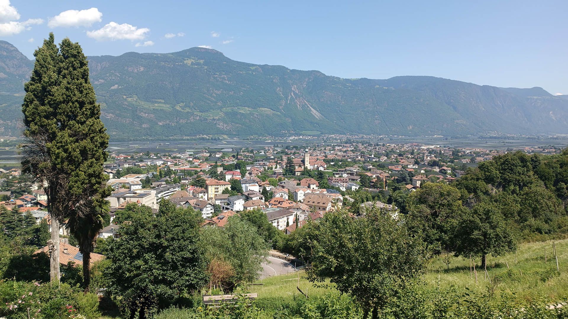Vista panoramica di Lana in Alto Adige, con case, campanile e montagne sullo sfondo