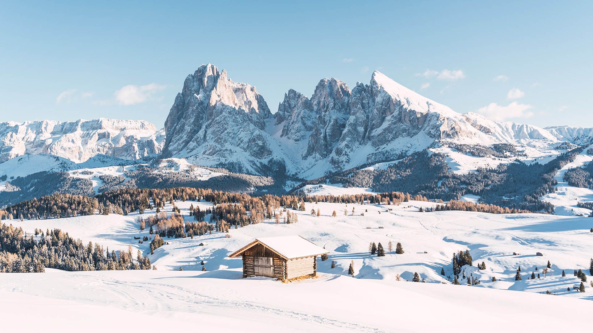 Escursionista invernale cammina sulla neve con vista sulle montagne innevate.