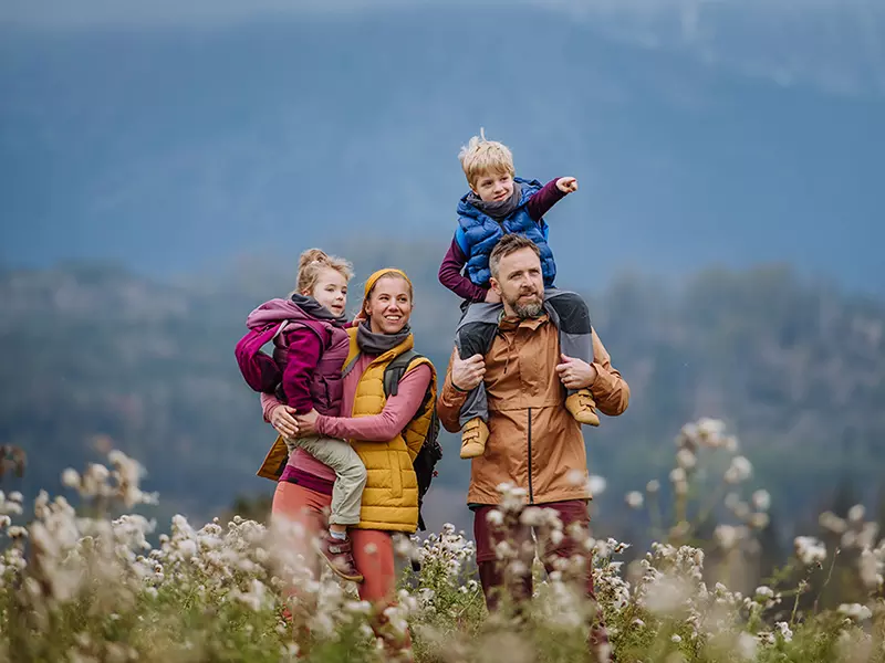 Famiglia con due bambini in escursione tra i fiori	